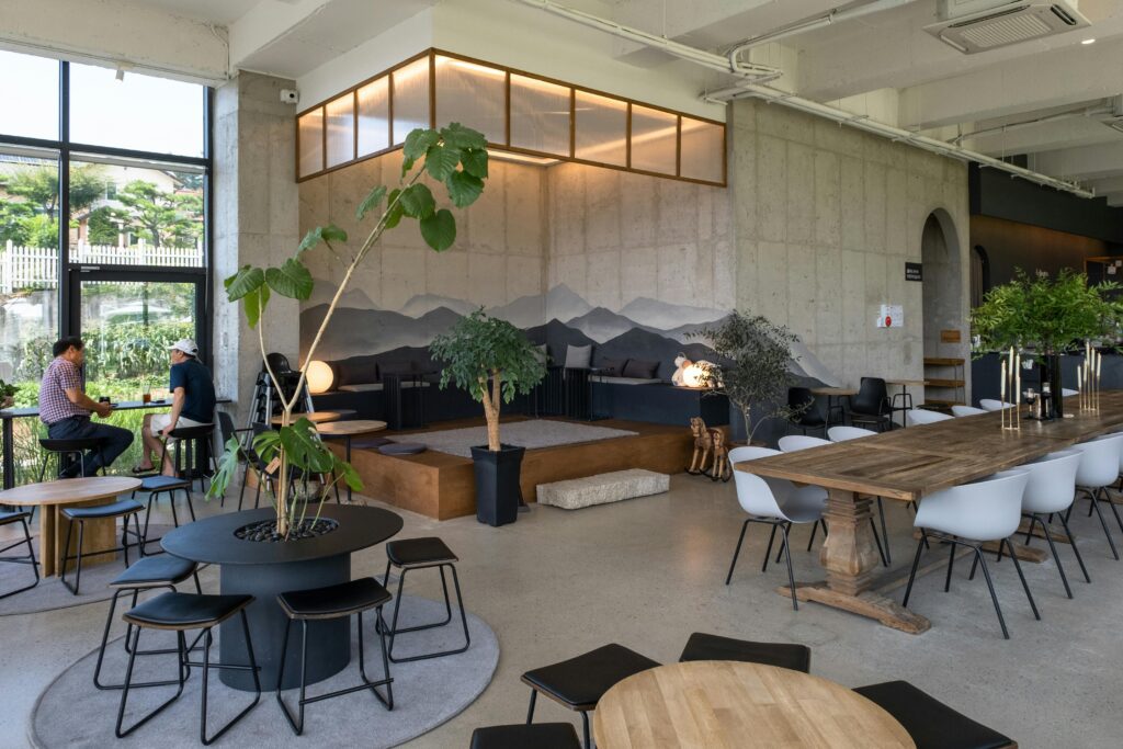 Modern café interior featuring stylish seating, plants, and natural lighting.