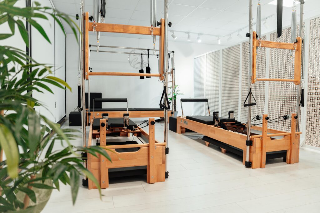 Bright and spacious Pilates studio with wooden equipment in a white room, Yalova, Türkiye.